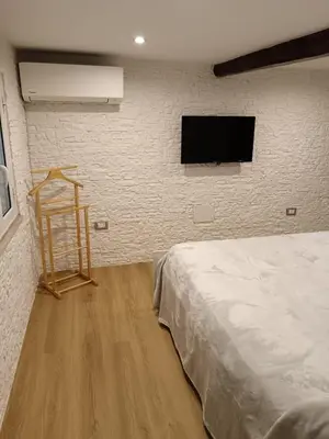 a bedroom with a bed and a flat screen tv at IGIEA APARTMENT in Palermo