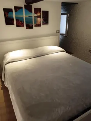 a white bed in a bedroom with pictures on the wall at IGIEA APARTMENT in Palermo
