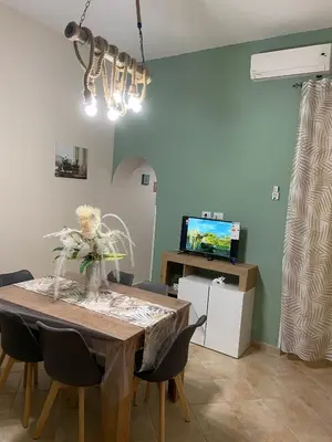 a dining room with a table with chairs and a television at CASA MAGIEM in Palermo