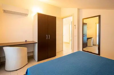 a bedroom with a mirror and a bed and a cabinet at Borgo Aranci - Villa Unifamiliare Ibiscus 08 in Castellammare del Golfo