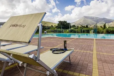 a bench sitting next to a swimming pool at Borgo Aranci - Villa Unifamiliare Ibiscus 08 in Castellammare del Golfo