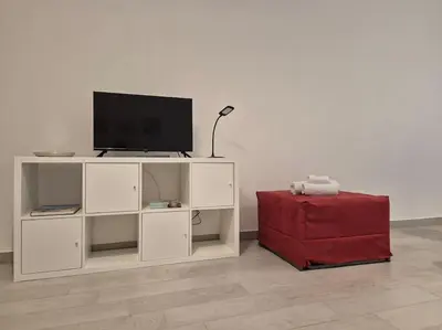 a bed in a room with two red tables at MaGi Mondello in Mondello