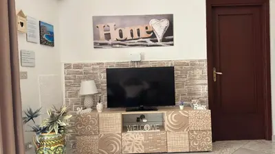 a flat screen tv sitting on top of a brick wall at Mona House accogliente casa vacanza in Palermo