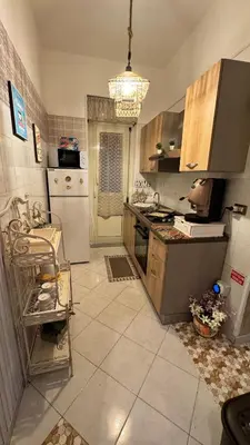 a kitchen with a stove and a refrigerator at Mona House accogliente casa vacanza in Palermo