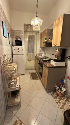 a kitchen with a stove and a white refrigerator at Mona House accogliente casa vacanza in Palermo