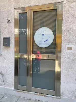 a person standing in front of a door with a clock at Mona House accogliente casa vacanza in Palermo