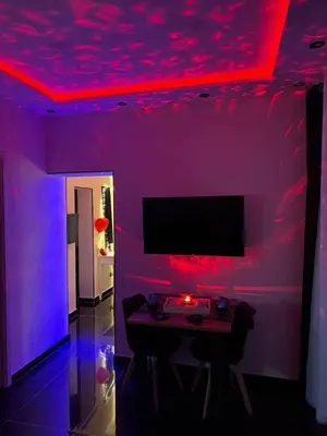 a purple room with a table and a tv at Holiday home Joy in Palermo