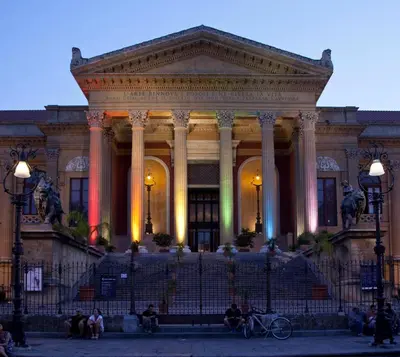 a large building with people sitting in front of it at Holiday home Joy in Palermo