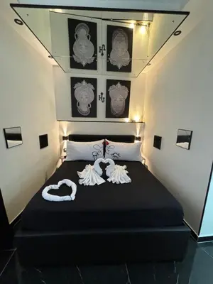 a bedroom with a black bed with towels on it at Holiday home Joy in Palermo