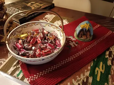 a bowl of candy on a table next to a book at We # Are ai Cassarelli in Palermo