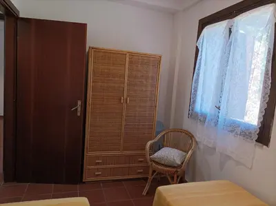 a bedroom with a cabinet and a chair and a window at La Terrazza su Pispisa in Castellammare del Golfo