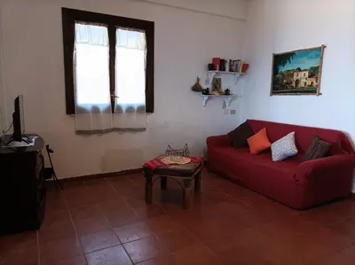a living room with a red couch and a window at La Terrazza su Pispisa in Castellammare del Golfo