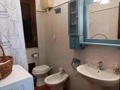 a bathroom with a sink and a toilet and a mirror at La Terrazza su Pispisa in Castellammare del Golfo