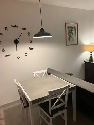 a dining room with a table and a clock on the wall at Albachiara Termini in Termini Imerese