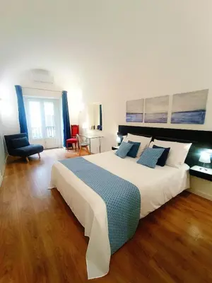 a bedroom with a bed and a chair and a desk at Quattro Canti - residenza Santa Caterina in Palermo