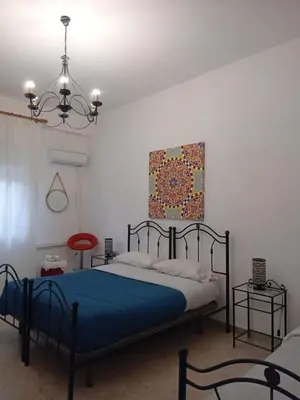 a bedroom with a blue bed and a painting on the wall at BBX Palermo 2 in Palermo