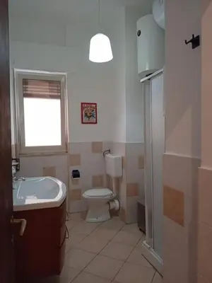 a bathroom with a toilet and a sink and a window at BBX Palermo 2 in Palermo