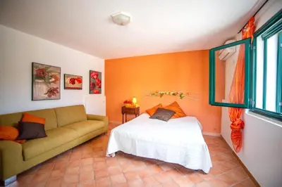 a living room with a bed and a couch at Villa Reyna in Scopello