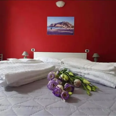 a white bed with a bouquet of flowers on it at B&B Villareale 35 in Palermo