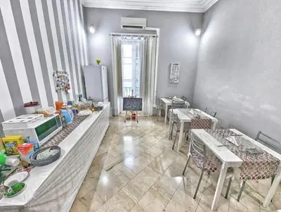 a dining room with tables and chairs and a refrigerator at B&B Villareale 35 in Palermo