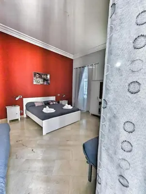 a bedroom with a bed and a red wall at B&B Villareale 35 in Palermo