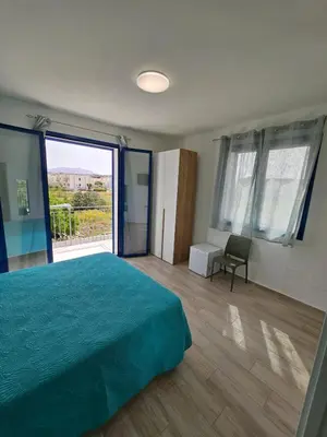 a bedroom with a green bed and a large window at Un Posto Al Sole in San Vito lo Capo