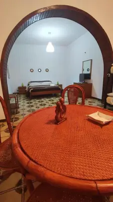 a room with a table and a bed in the background at Casa Di Mitri in Carini