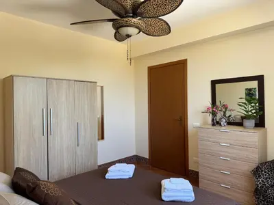 a bedroom with a bed and a dresser and a ceiling fan at Le Casette di Campagna in Campofelice di Roccella