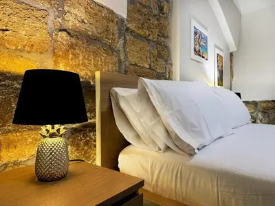a bedroom with a bed and a table with a lamp at MaMa7 in Palermo