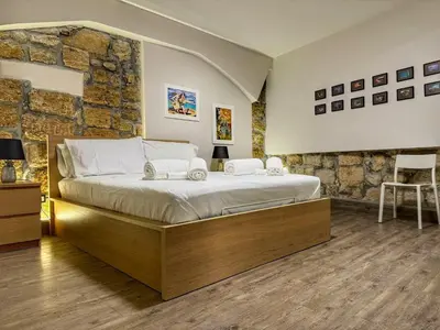 a bedroom with a large bed and a stone wall at MaMa7 in Palermo