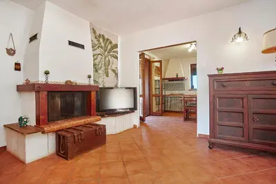 a living room with a flat screen tv and a tv at VILLa CON PISCINA SCOPELLO in Castellammare del Golfo