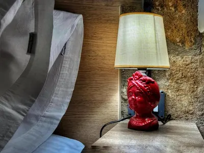 a red lamp sitting on a table next to a bed at MaMa5 in Palermo