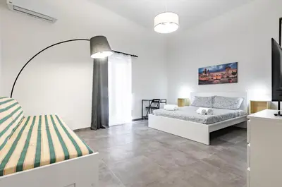 a bedroom with two beds and a large window at GuestHost - Palazzo dei Normanni & Ballarò Roomy Modern Apt x9 in Palermo