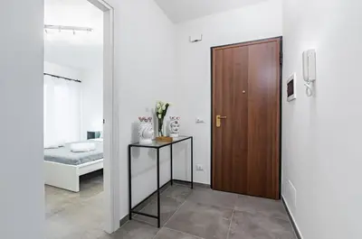 a hallway with a door and a table with flowers at GuestHost - Palazzo dei Normanni & Ballarò Roomy Modern Apt x9 in Palermo