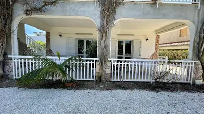 a house with a white fence and a tree at Residence Cavalluccio Marino in Alcamo Marina