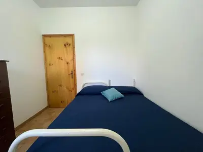 a bedroom with a blue bed and a wooden door at Residence Cavalluccio Marino in Alcamo Marina