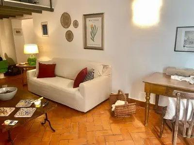 a living room with a white couch and a table at Cathedral cozy apartment in Palermo