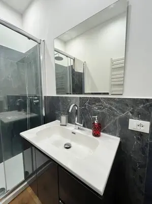 a bathroom with a white sink and a shower at Lazio apartment nel centro di Palermo in Palermo