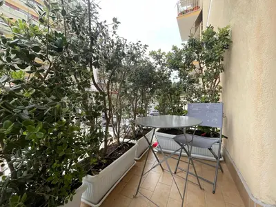 a table and chairs on a balcony with trees at Lazio apartment nel centro di Palermo in Palermo