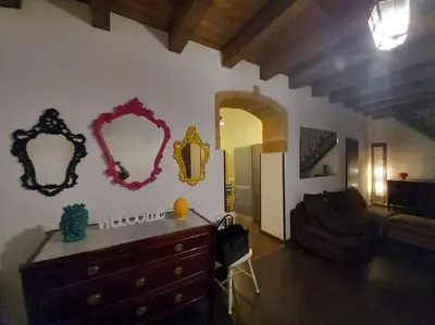 a living room with a dresser and mirrors on the wall at Casa Bosco a Ballarò in Palermo