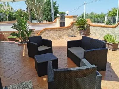 a patio with two chairs and a couch at Holiday House Nonna Grazia in Trappeto