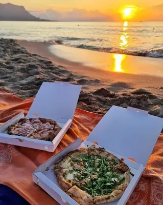 two pizzas sitting on a blanket on the beach at Holiday House Nonna Grazia in Trappeto