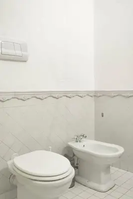 a white bathroom with a toilet and a sink at Cavour Elegant apartment At Massimo Theater in Palermo
