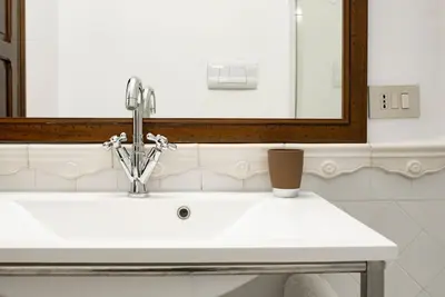 a bathroom with a sink and a mirror at Cavour Elegant apartment At Massimo Theater in Palermo