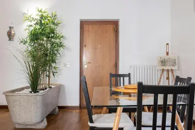 a dining room with a table and a potted plant at Cavour Elegant apartment At Massimo Theater in Palermo
