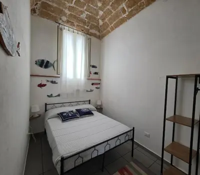 a small bedroom with a bed and a window at 'a casetta - Sferracavallo in Palermo