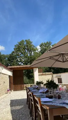 a row of tables and chairs with an umbrella at Fattoria F.lli Marsolo in Chiusa Sclafani