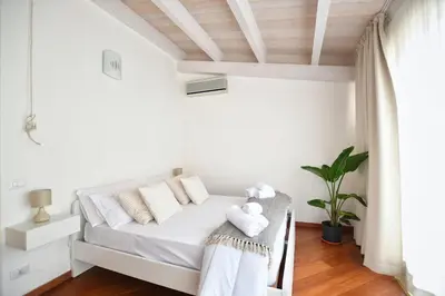 a white bedroom with a bed with white pillows at iFlat Casa Viscuttara in Palermo