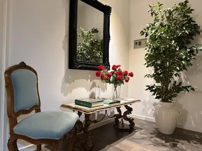 a table with a chair and a mirror and flowers at Victoria's Apartment in Palermo