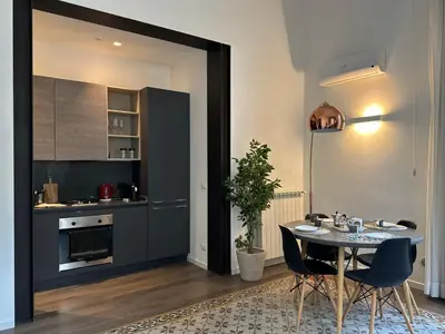 a kitchen with a table and chairs in a room at Victoria's Apartment in Palermo